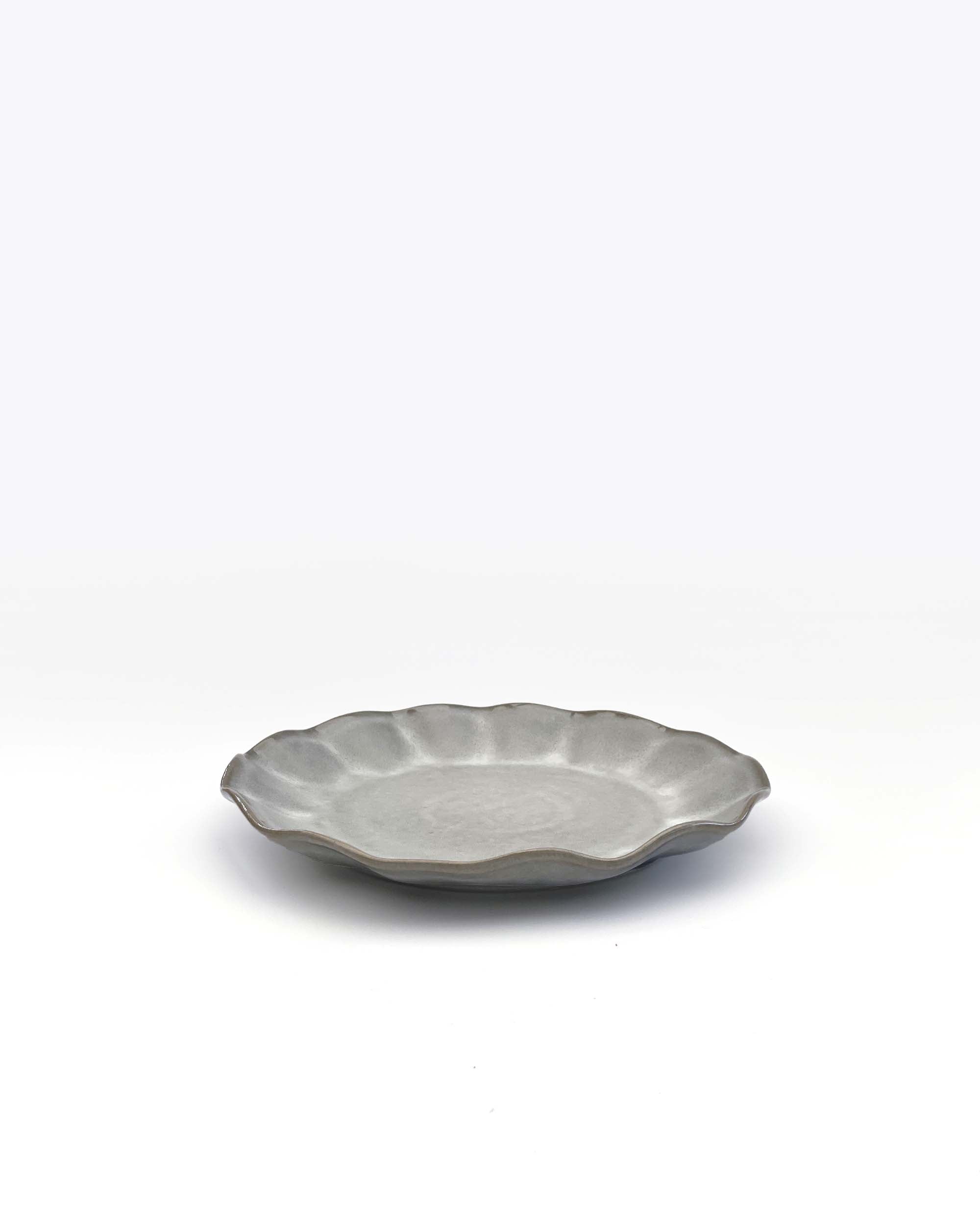 Norling  Studio tallrik - Farrago Wave tallrik med vågig kant i grått, vit bakgrund